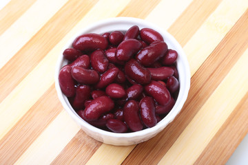 Heap of canned red kidney beans in the sauce in white bowl. vegetarian food. Phaseolus vulgaris.