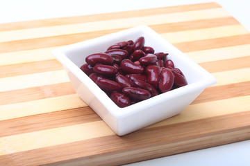 Heap of canned red kidney beans in the sauce in white bowl. vegetarian food. Phaseolus vulgaris.