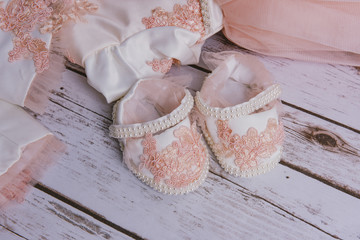 Little girl shoes and dress on a wood background