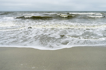 Landscape with The Black sea, sand and beach elements photographed in Gura Portitei, Romania, in a foggy spring day