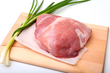 pork steaks with fat. Meat is on wooden board with spice as pepper and green spring onion. Ready for cooking. Selective focus.