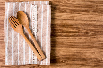 Wooden spoon and fork  on fabric with wooden table.