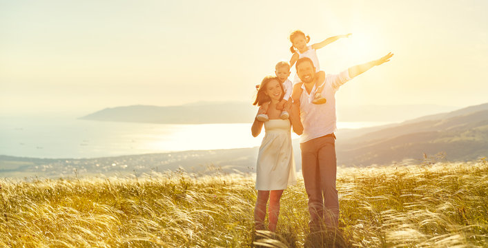 Happy family: mother, father, children son and daughter on sunset