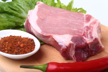 Fototapeta premium Raw pork chops with herbs and spices on cutting board. Ready for cooking.