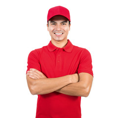 Smiling delivery man in red uniform standing with arm crossed