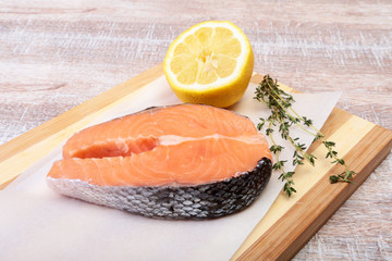 fresh raw salmon with spices and lemon on wooden cutting board. ready for cookin
