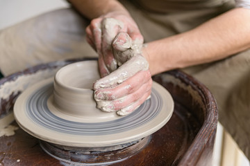 Hands working on pottery wheel