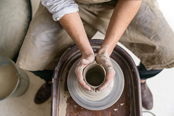 Fototapeta premium Hands working on pottery wheel
