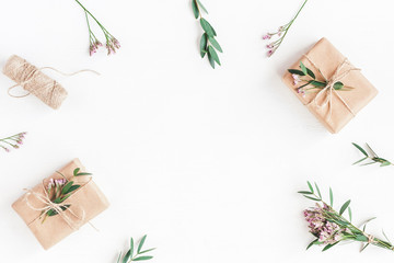 Flowers composition. Gifts, pink flowers and eucalyptus branches on white background. Flat lay, top view