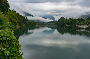 Fototapeta na wymiar Mountain river landscape in the morning with low clouds and fog