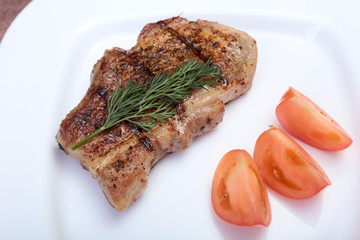 grilled pork chop with vegetable on plate on wooden board