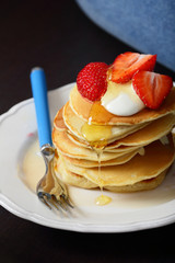 Juicy breakfast pancakes with strawberries on white plate, flowing honey, food, fork, healthy lifestyle