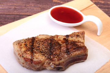 grilled pork chop with Cranberry sauce on plate on wooden board