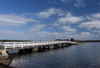Fototapeta na wymiar Bridge across Wallaga Lake. The famous and spiritual area of Wallaga Lake, the largest lake in southern NSW, near Bermagui in New South Wales, Australia.