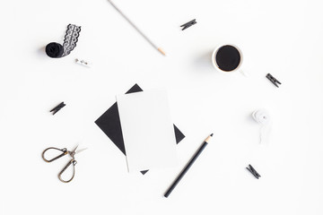 Stylish feminine workspace with paper blank, cup of coffee, accessories. Flat lay, top view