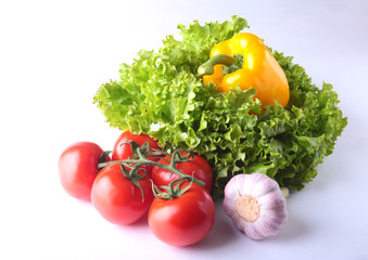 Fresh assorted vegetables bell pepper, tomato, garlic with leaf lettuce. Isolated on white background. Selective focus.