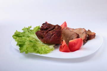 Steak of grilled meat with tomato, lettuce and beans pomegranate on white plate.