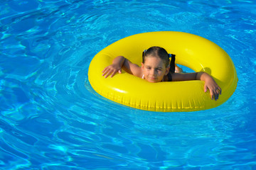 Adorable toddler relaxing in swimming pool