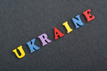 Ukraine word on black board background composed from colorful abc alphabet block wooden letters, copy space for ad text. Learning english concept.