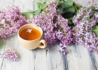 Morning on table with cup of tea and flowers