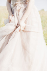 Hands of bride on wedding dress on sunny day. fine art photography.