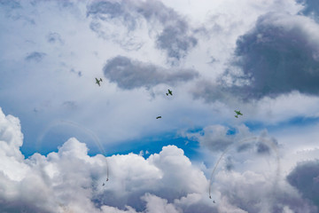 The parade of aircraft in the daytime blue sky in the bright and dark clouds
