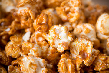 Caramel opcorn in bowl on the wooden table.