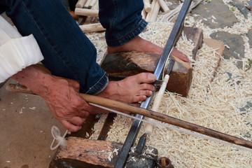 Carpenter working wood with feet and hands