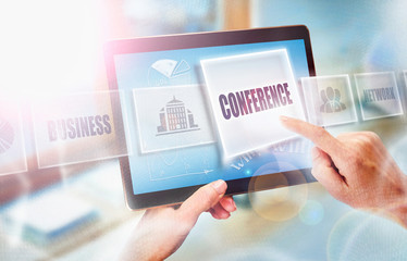 A businesswoman selecting a Conference business concept on a futuristic portable computer screen.