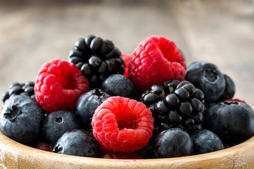 Healthy berries in wooden bowl on wooden table
