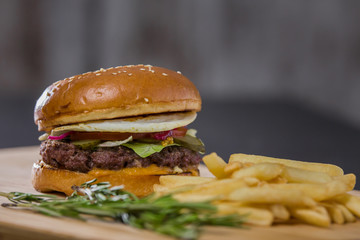 Big fresh appetizing burger with pepper and potatoes