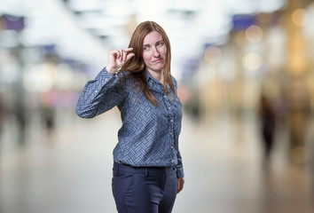 Fototapeta premium Pretty business woman doing tiny sign over blur background