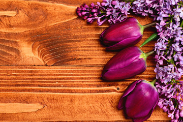 Decorated warm brown wood surface with purple tulip and lilac