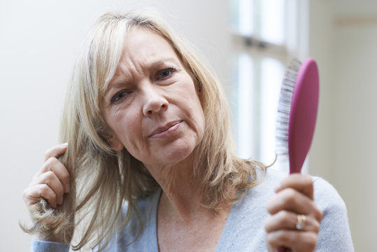 Mature Woman With Brush Corncerned About Hair Loss