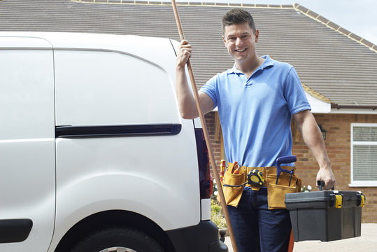 Plumber With Van Talking On Mobile Phone Outside House