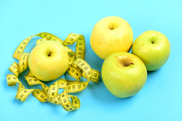 Tape for measuring or flexible ruler and green apples