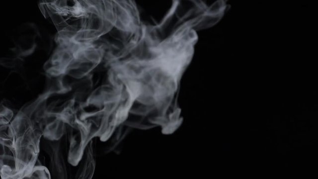 Smoke billowing over a black background.
