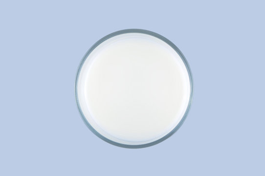 Top view of a glass of milk isolated on the light blue background