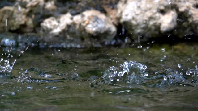 splash close-up falling water drops hits and explodes slow motion