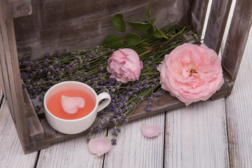 Vintage cup with heart on the background of lavndy and roses