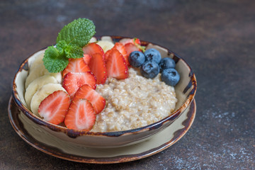 Bowl of delicious steel cut oats with fresh fruit, honey