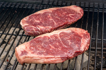 raw beef steaks on a grill