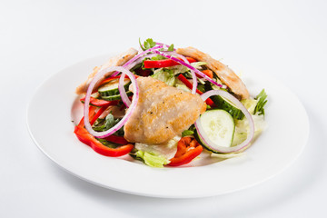 salad with chicken on a white plate on a light background (close)