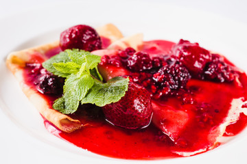 Sweet dessert. Pancakes with berry of the strawberry and raspberry sauce (close)