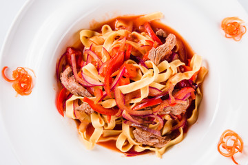 Pasta with beef, peppers, tomatoes and onions (close top view)