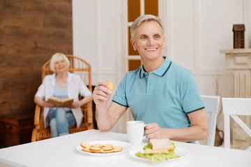 Fototapeta na wymiar Nice clever senior man having a healthy breakfast