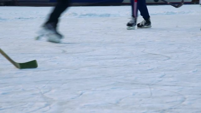 People play hockey on a frozen river, teammates pass the puck to one another -