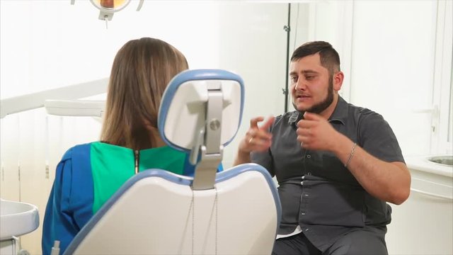 male orthodontist is conducting a primary consultation for a woman who came to the oral cavity. A young woman wants to get rid of tooth decay in a dental hospital where there are professional doctors