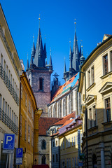 The Church of our Lady before Tyn from an intersting perspective as seen from a sidewalk with colorful buildings on both sides. Prague, Czech Republic