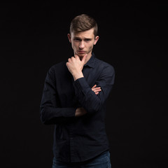 Young man portrait of a confident businessmanon black background. Ideal for banners, registration forms, presentation, landings, presenting concept.